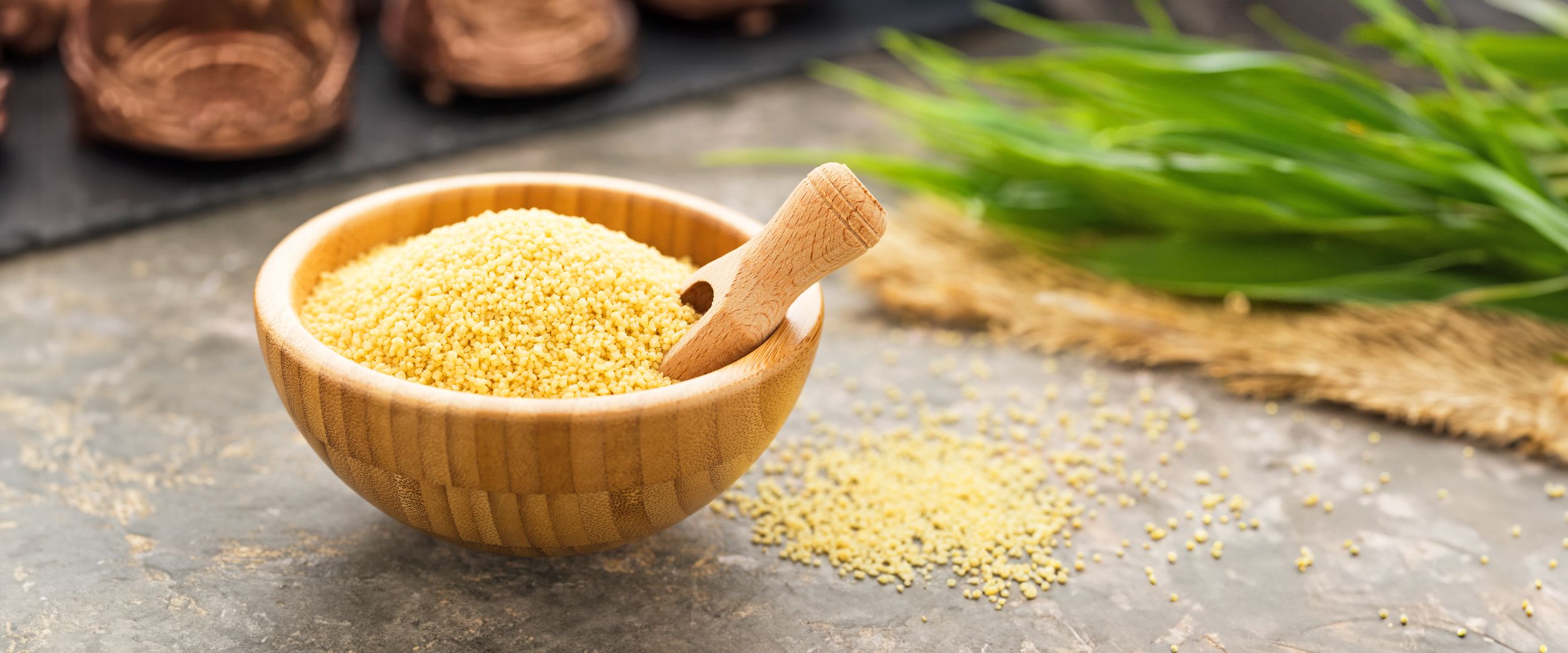 Bambusschale mit trockenem Bulgur und einem kleinen Holzschäufelchen