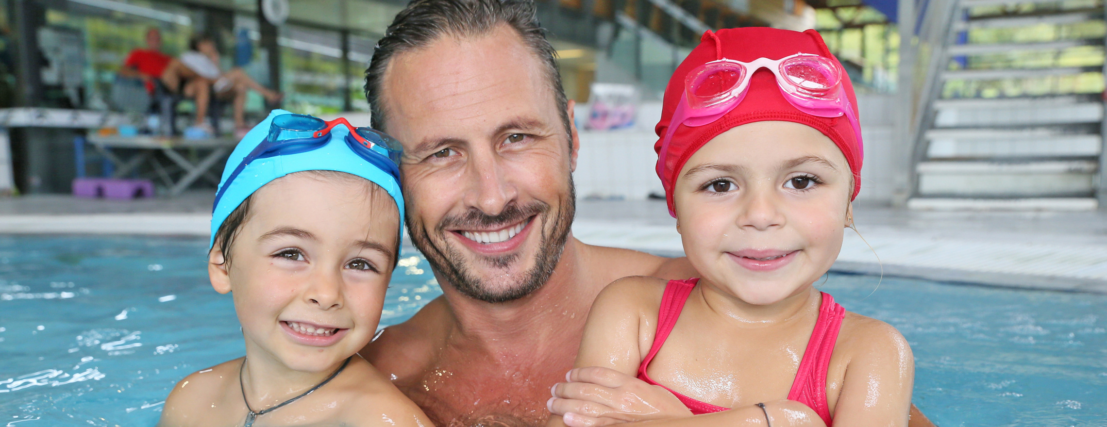 Vater mit Sohn und Tochter im Hallenbad